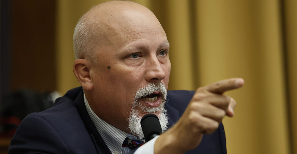 Texas Representative Chip Roy gestures in a suit