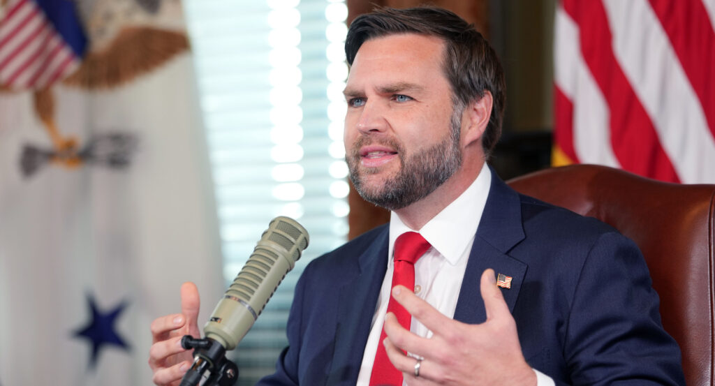 Vice President JD Vance is sitting down talking into a podcast microphone.