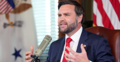 Vice President JD Vance is sitting down talking into a podcast microphone.