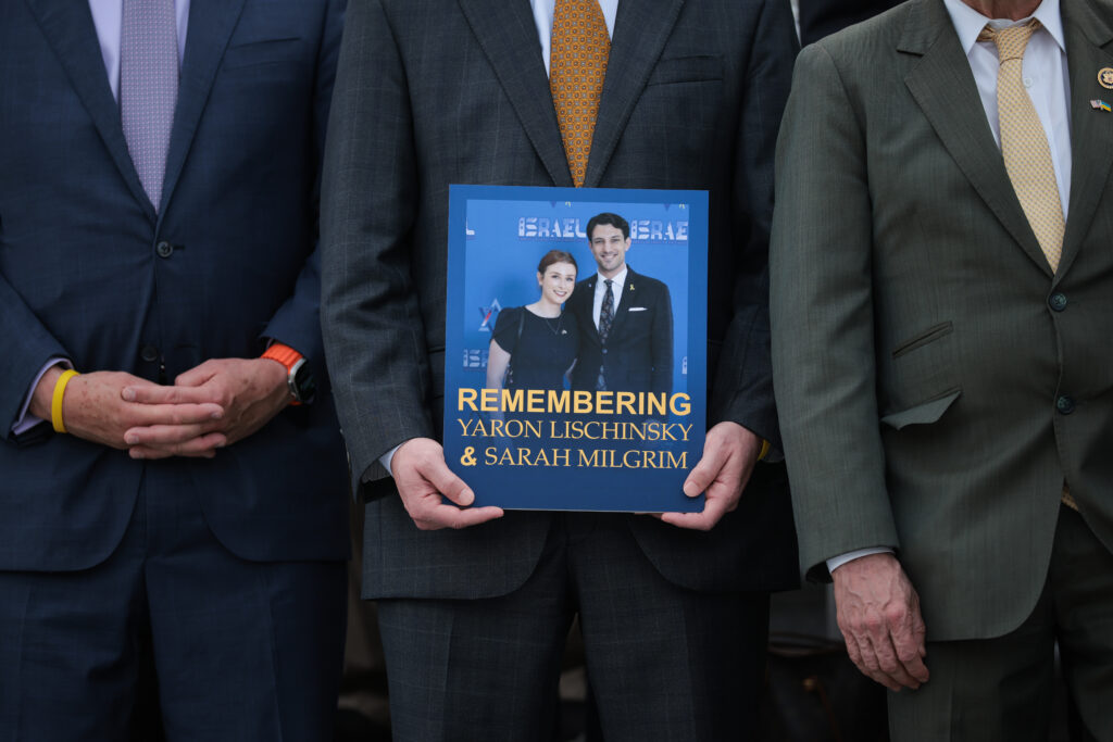 A picture of Sarah Milgrim and Yaron Lischinsky is held up at their memorial.
