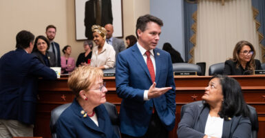 Reps. Marcy Kaptur, Brendan Boyle, and Pramila Jayapal talk amongst themselves in committee during a bill markup.