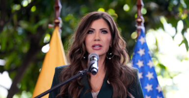 Department of Homeland Security Secretary Kristi Noem speaks at a podium outdoors.
