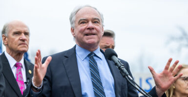 Tim Kaine in a blue suit gestures wildly