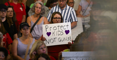 People attend a press conference with city officials and gun legislation advocates following a mass shooting at Annunciation Catholic School.