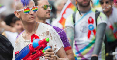 A man cools down spectators with his water gun as he marches in the Pride Parade.