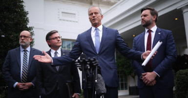 John Thune, arms outstretched speaks outside the White House, flanked by JD Vance, Mike Johnson and Russell Vought.