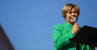 Charlotte, N.C., Mayor Vi Lyles, clad in green, speaks into a microphone at an outdoor event.