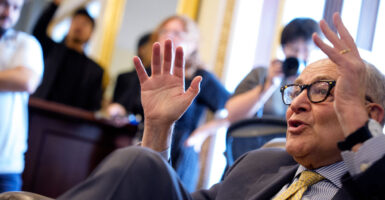 A nearly recumbent Senate Minority Leader Chuck Schumer, D-N.Y., speaks with reporters at the Capitol on Wednesday.