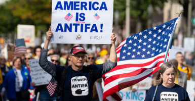 Leftist protesters march down Pennsylvania Avenue Northwest in Washington, D.C., on Saturday in an anti-Trump "No Kings" rally. Two of the protesters are wearing "I'm with Antifa" shirts and one of them is carrying a sign that reads "America is Antifa."
