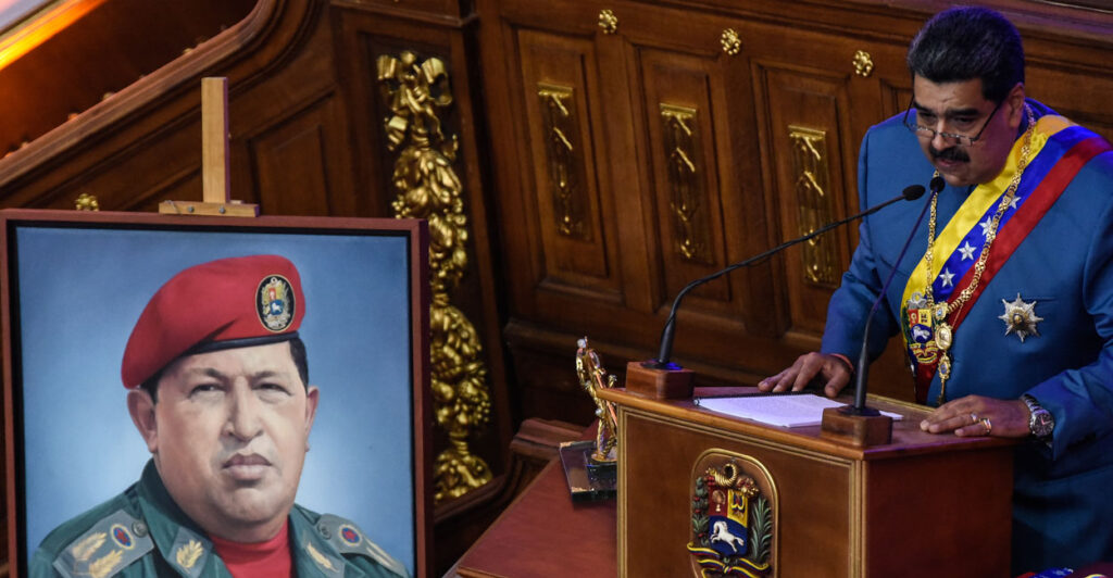 Venezuelan President Nicolas Maduro speaks next to an image of the late former Venezuelan strongman Hugo Chavez at a State of The Nation address on Jan. 12, 2021, in Caracas, Venezuela.