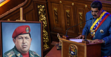 Venezuelan President Nicolas Maduro speaks next to an image of the late former Venezuelan strongman Hugo Chavez at a State of The Nation address on Jan. 12, 2021, in Caracas, Venezuela.