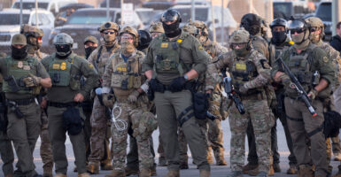 U.S. Immigration and Customs Enforcement agents, Department of Homeland Security personnel, and Border Patrol Commander Gregory Bovino stand together amid a protest outside the ICE processing facility in Broadview, Illinois, on Sept. 27.