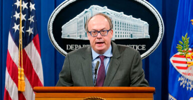 Jeffrey Clark stands at a podium backed by Department of Justice sign.