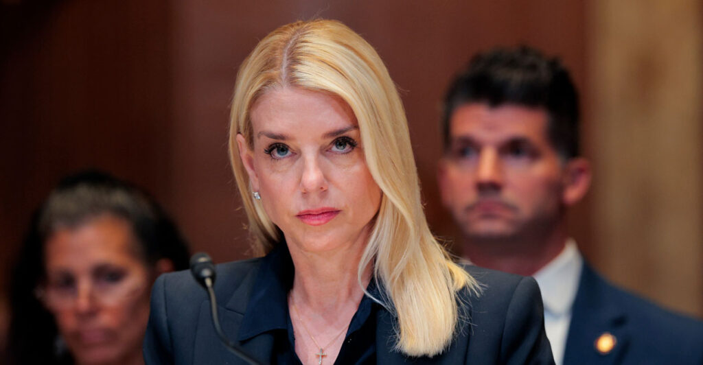 Pam Bondi in black suit stares into the camera during a congressional hearing.