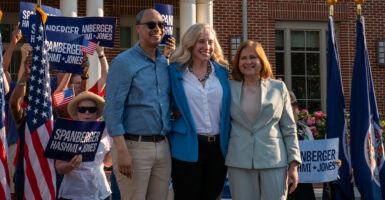 Jay Jones, Abigail Spanberger and Ghazala Hashmi link arms during a campaign rally.