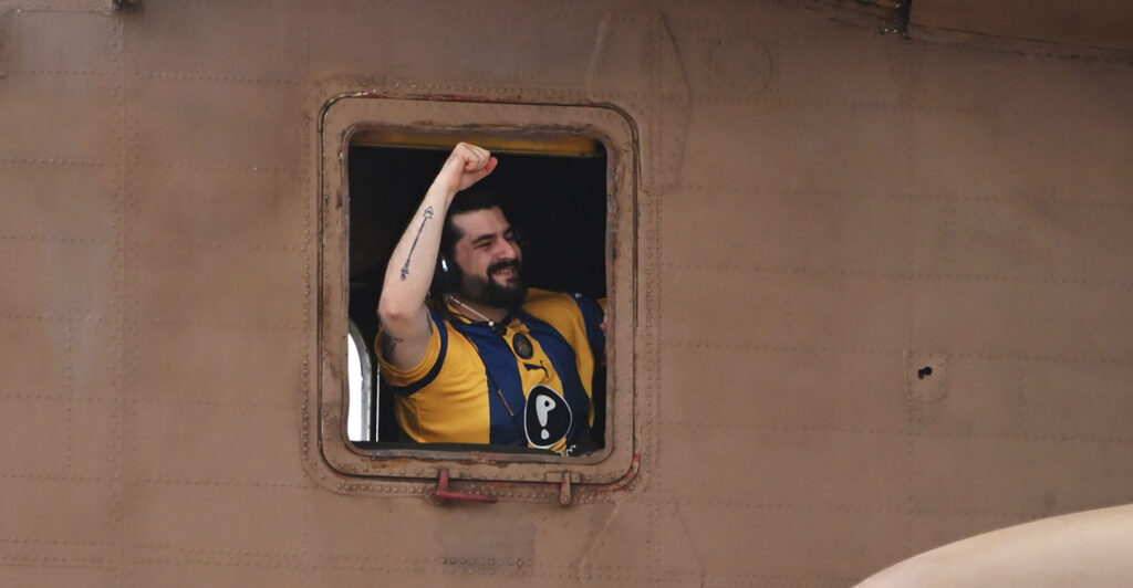 Former hostage Ziv Berman in the window of a helicopter, his fist pumped, celebrates his freedom.