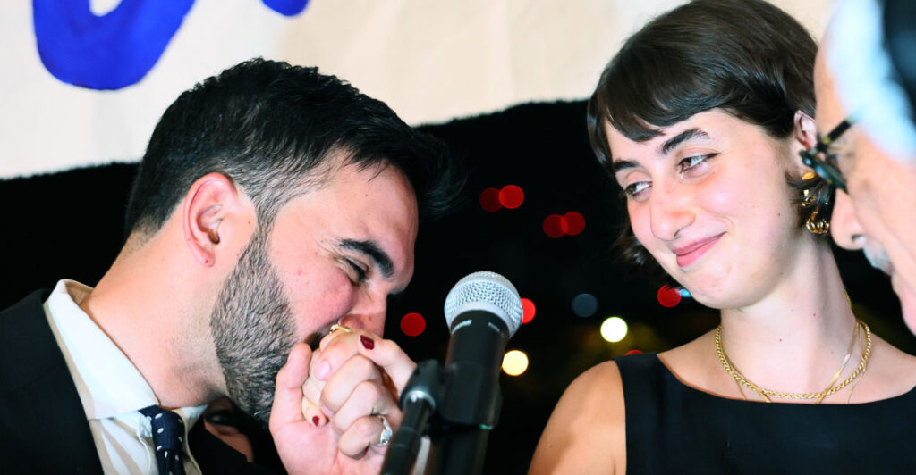 Zohran Mamdani kisses the hand of his wife Rama Duwaji.