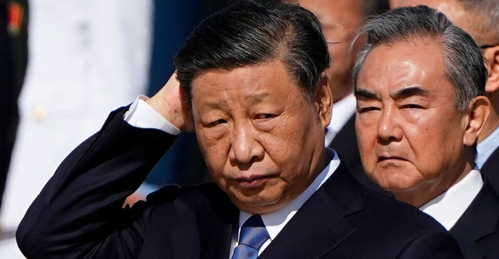Xi Jinping, with his hand against the back of his head.