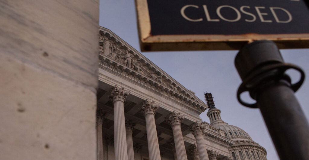 Low angle shot of the US Capitol with a "closed" sign.