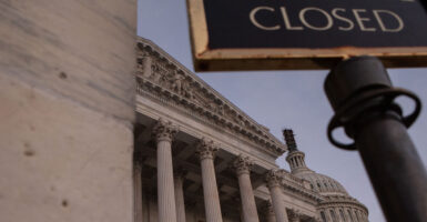Low angle shot of the US Capitol with a "closed" sign.