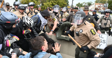 Anti-ICE protesters clash with Illinois State Police, including officer on the ground subduing a suspect.