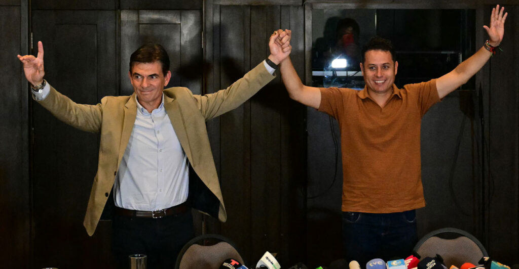 Bolivia's president and vice-president elect Rodrigo Paz and Edman Lara, with their arms raised, celebrate their election victory.