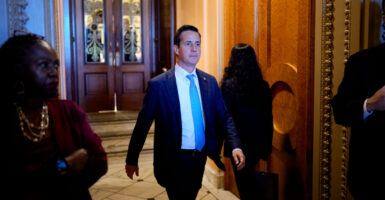 Sen. Bernie Moreno looks forward as he walks through the Senate.