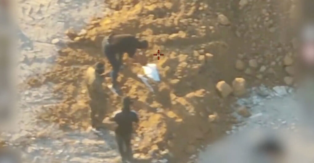 Overhead shot of alleged Hamas members burying a body.