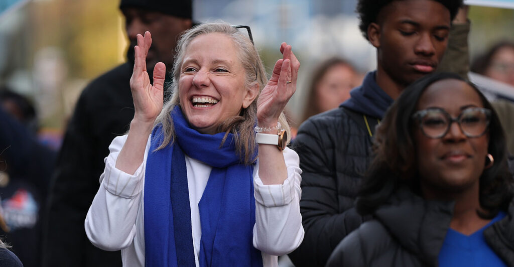Abigail Spanberger laughing and clapping.