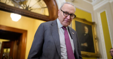 Senate Minority Leader Chuck Schumer, D-N.Y., walks out of a room at the Capitol.