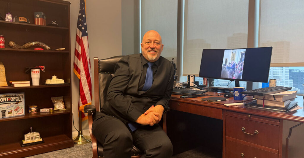 State Rep. Gary Click smiles as he sits at his office desk.