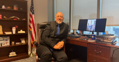 State Rep. Gary Click smiles as he sits at his office desk.
