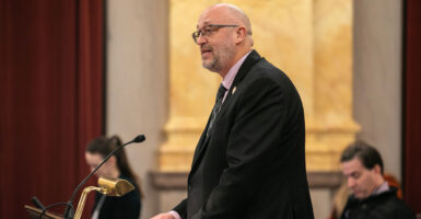 State Rep. Gary Click stands at a podium to speak at a hearing.