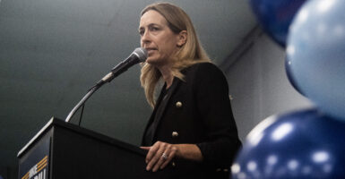 New Jersey gubernatorial candidate Mikie Sherril, in a dark suit, addresses an indoor rally.
