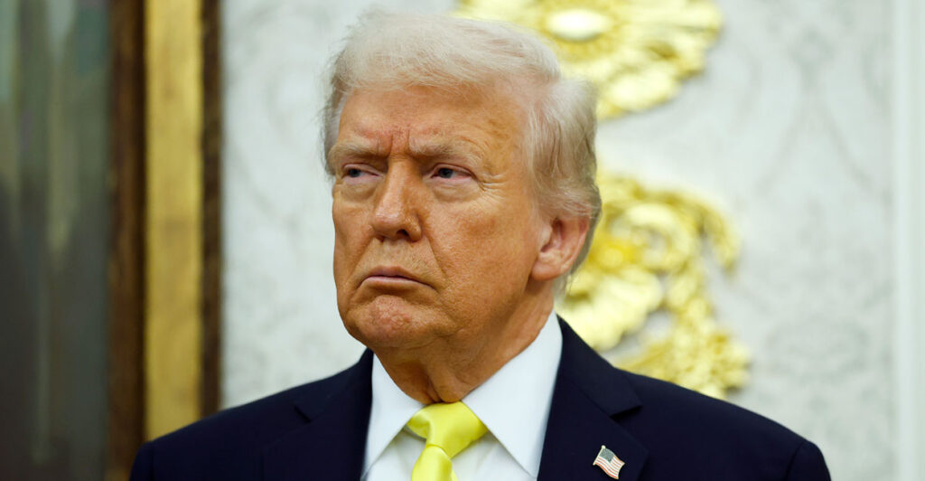 President Donald Trump exhibits a stern expression in the Oval Office.
