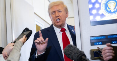 President Donald Trump speaks to reporters aboard Air Force One on Monday.