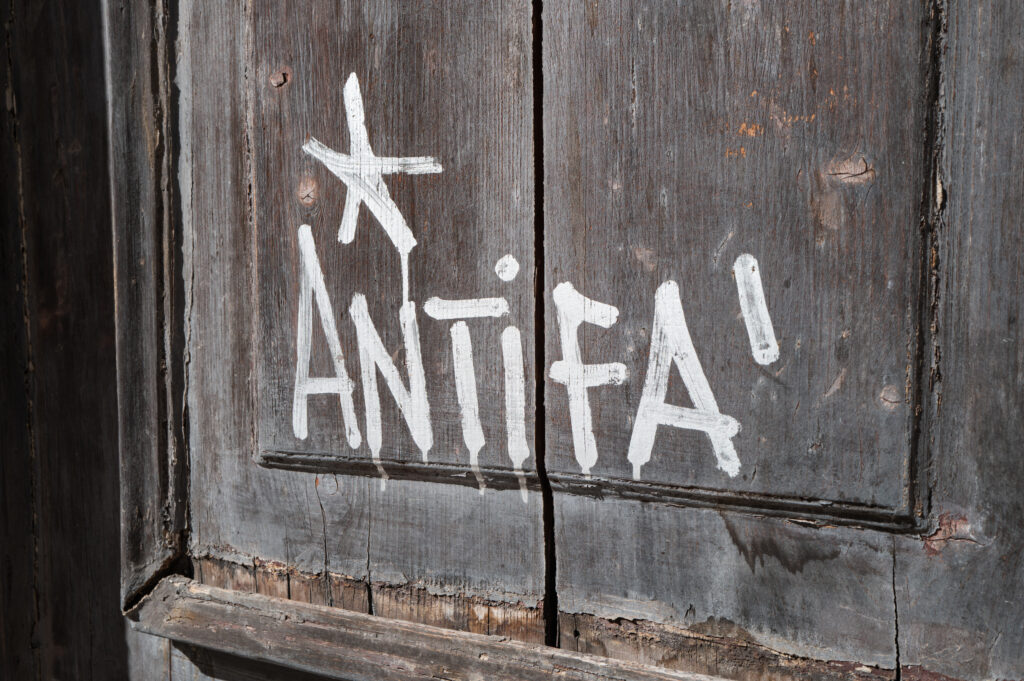 Graffiti reading ''Antifa'' is painted in white on the wooden door of a university building in Bari, Italy, on Sept. 19.