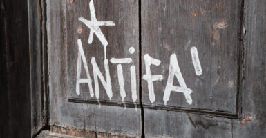 Graffiti reading ''Antifa'' is painted in white on the wooden door of a university building in Bari, Italy, on Sept. 19.