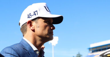 Secretary of War Pete Hegseth is shown wearing a white Make America Great Again hat.