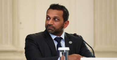 FBI Director Kash Patel is sitting and looking to his right.