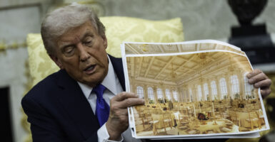 President Donald Trump speaks holding a photos of the new ballroom during a meeting with NATO Secretary General Mark Rutte in the Oval Office of the White House in Washington, DC on October 22, 2025.