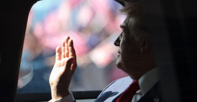 President Donald Trump waves from his official vehicle known as "The Beast" as he departs from Kuala Lumpur International Airport