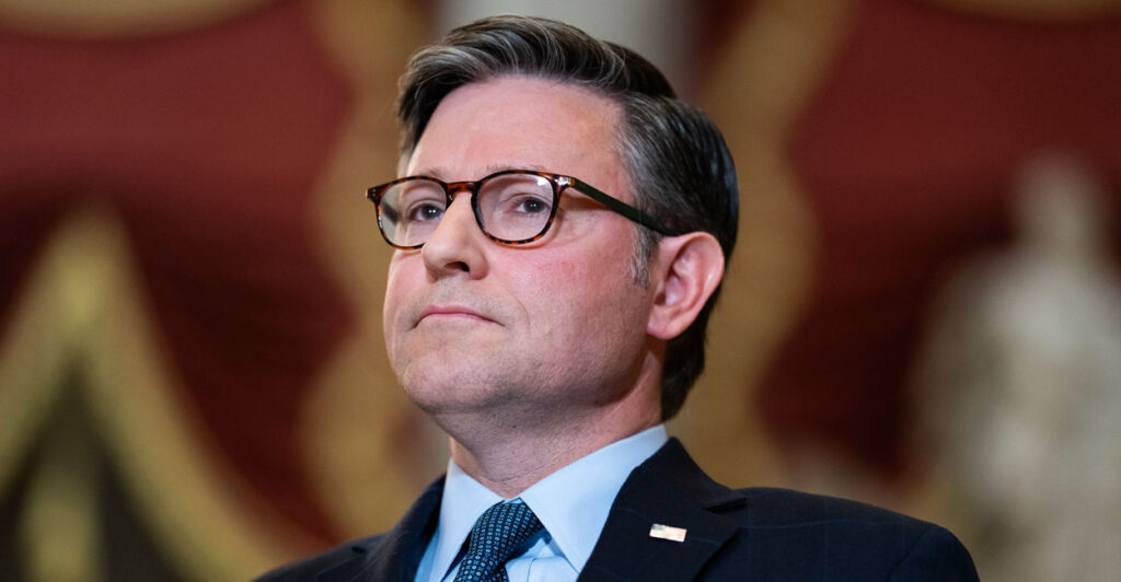 Speaker Johnson stands at a lectern during a press conference.