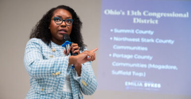 Rep. Emilia Sykes stands by a projector at a town hall event.