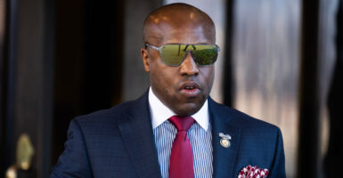 Wesley Hunt, wearing a suit and reflective sunglasses, exits the Capitol Hill Club in Washington, D.C.