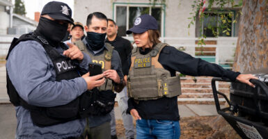 Homeland Security Secretary Kristi Noem stands with ICE agents.