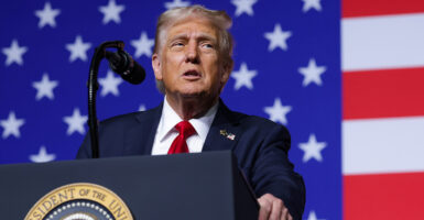 President Donald Trump with a huge American flag as backdrop