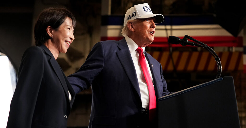 President Trump in a white USA hat with blue lettering, stands with Japanese Prime Minister Sanae Takaichi.