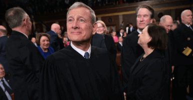 Chief Justice John Roberts and Justce Brett Kavanaugh clap in robes