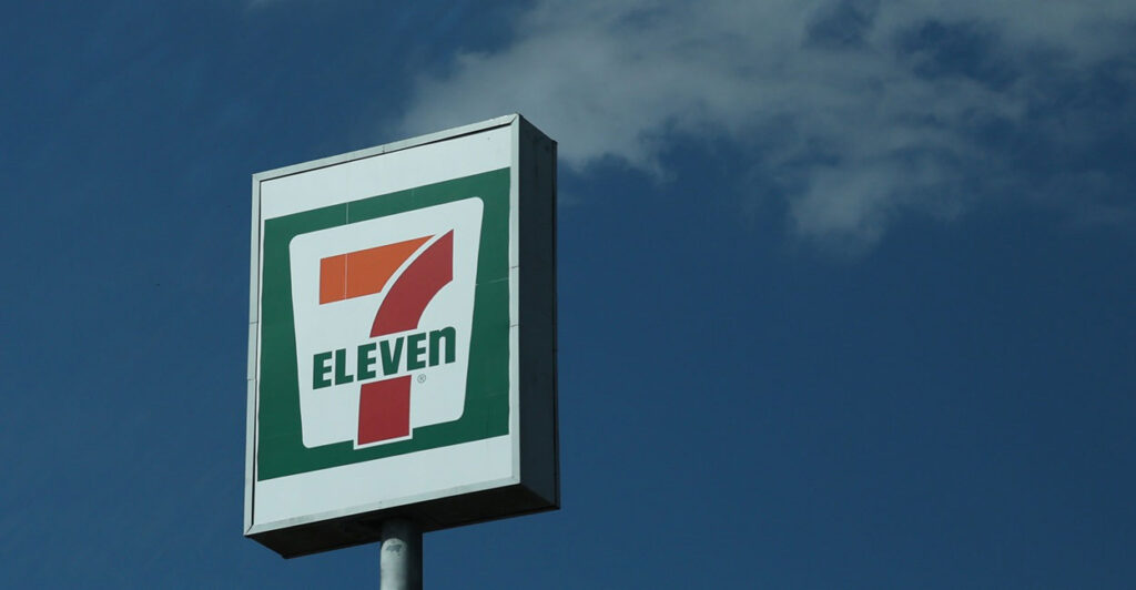 A 7 Eleven sign stands out against a blue sky.